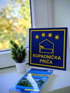 a sign sitting on a table next to a plant at Kopaonička priča in Kopaonik