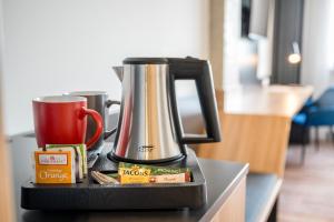 a coffee maker sitting on top of a counter with a cup at N+S City Hotel Neumarkt in Neumarkt in der Oberpfalz