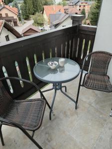 Una mesa y dos sillas en un balcón. en Apartman Havjar Zlatibor, en Zlatibor 5 fotos más