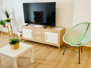 a living room with a television and a chair at Casa La Martinica in Almagro