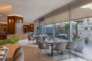 un ristorante con tavoli, sedie e finestre di Radisson Blu Hotel, Amman Galleria Mall ad Amman