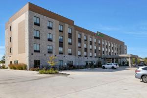 a building with a car parked in front of it at Holiday Inn - Chicago - Tinley Park by IHG in Tinley Park