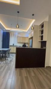 a living room with a table and a kitchen at Petal & Palm in Buye +11 photos