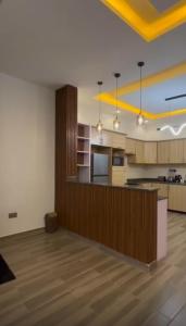 an empty room with a kitchen with a counter at Petal & Palm in Buye