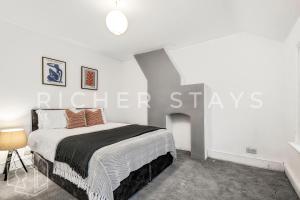 Ένα ή περισσότερα κρεβάτια σε δωμάτιο στο Homely 3-Bedroom Retreat with Garden & Living Room