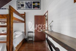 a bedroom with two bunk beds and a desk at Suíte Left – Paraíso dos Ciclistas in Gramado