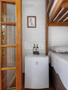 a room with a bed and two bottles of wine at Suíte Left – Paraíso dos Ciclistas in Gramado