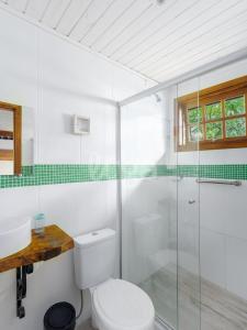 a bathroom with a toilet and a glass shower at Suíte Left – Paraíso dos Ciclistas in Gramado