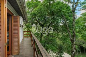 a staircase leading to a house with a sign on a tree at Suíte Left – Paraíso dos Ciclistas in Gramado