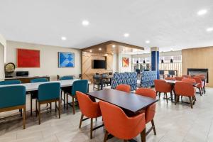 a waiting area with tables and chairs in a waiting room at Holiday Inn Express Hotel & Suites Council Bluffs - Convention Center Area by IHG in Council Bluffs