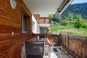une terrasse en bois avec une table et des chaises dessus dans l'établissement Sonne Oase mit Sauna, à Fiesch