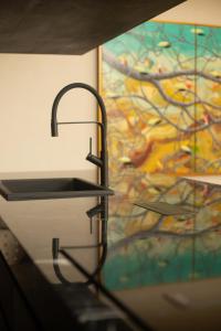 ein Waschbecken in einem Raum mit einem Gemälde an der Wand in der Unterkunft Five Stories Villas By SUOM in Canggu + 26 Fotos