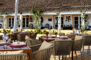 un ristorante all'aperto con tavoli e sedie in legno di Herdade Do Sobroso Wine & Luxury Boutique Hotel a Pedrógão