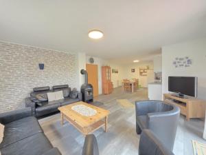 Komfortferienhaus Küstenruhe Norddeich في Flüthörn: غرفة معيشة مع أريكة وطاولة وتلفزيون