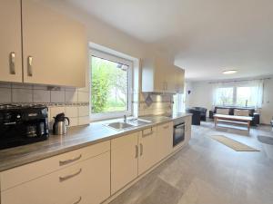 Komfortferienhaus Küstenruhe Norddeich في Flüthörn: مطبخ مع حوض وطاولة عمل