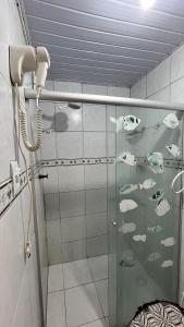 a shower with a glass door with fish in it at Apartamento Vila Isabel in Maragogi +13 photos
