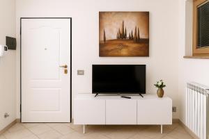 salon z telewizorem na białej szafce w obiekcie Studio Sole e Residenza Luna Assisi w Asyżu