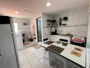 a white kitchen with a counter and a refrigerator at Apartamento Vila Isabel in Maragogi