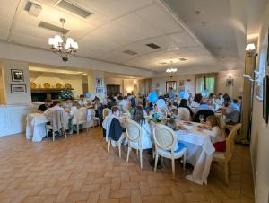 a group of people sitting at tables in a restaurant at Saturnia Tuscany Country House in Saturnia