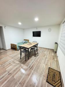 a room with a table and chairs and a tv at Apart Ayres in Río Gallegos