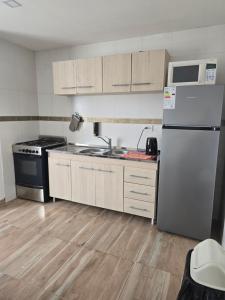 Apart Ayres -Planta alta في ريو جاليجوس: مطبخ مع ثلاجة بيضاء وموقد