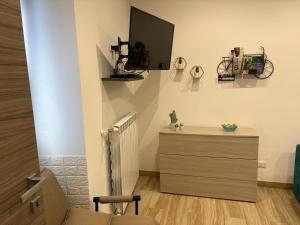 a room with a dresser and a tv on the wall at Sweet home in Isnello