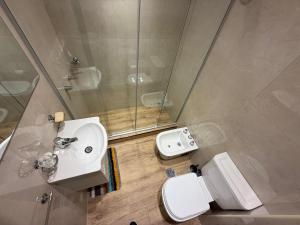 Un baño con inodoro, lavabo y ducha. en Departamento reciclado, en Mar del Plata