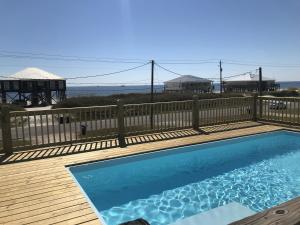 a swimming pool on a deck with a fence at Stay AWhile in Dauphin Island