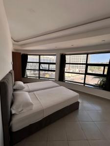 a bedroom with a bed and two large windows at Sunrise studio in Tangier