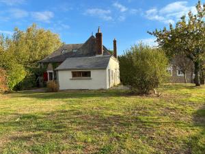 an old white house with a window on a yard at La Maison du Clocher in Jupilles