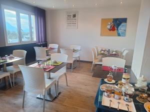 a restaurant with tables and chairs with food on them at Hotel le Foron in La Roche-sur-Foron