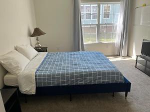 Un dormitorio con una cama con una manta azul y blanca. en Saint Andrews 3BD & 2BTH, en Columbia