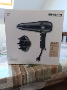 a black hairdryer in a box on a table at résidence KAKIKA in Verviers +4 photos