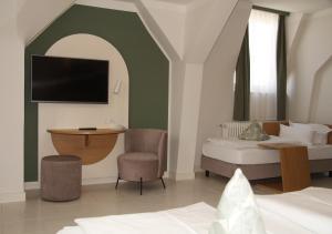 a hotel room with a bed and a tv on the wall at Gästehaus Centro in Konstanz in Konstanz