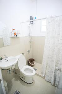 a white bathroom with a toilet and a sink at Casa de Amor Modern Comfort across the pool in Dauis