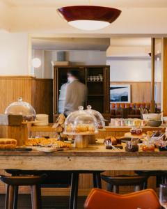 a man standing behind a counter in a restaurant at Le Val Thorens, a Beaumier hotel in Val Thorens