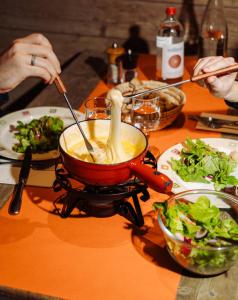 a person cooking food in a pot on a stove at Le Val Thorens, a Beaumier hotel in Val Thorens