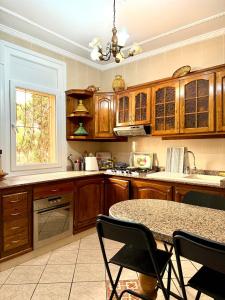 a kitchen with wooden cabinets and a table with chairs at Résidence familiale Agadir, 15 mins de la plage in Agadir