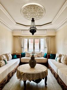 a living room with two couches and a table at Résidence familiale Agadir, 15 mins de la plage in Agadir