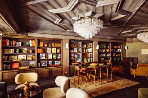 a dining room with a chandelier and a table and chairs at Le Fitz Roy, a Beaumier hotel in Val Thorens