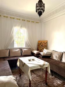 a living room with a couch and a table at Résidence familiale Agadir, 15 mins de la plage in Agadir +8 photos