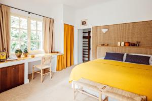 a bedroom with a yellow bed and a desk at Le Moulin, Lourmarin, a Beaumier Hotel in Lourmarin