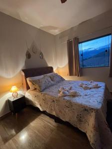 a bedroom with a large bed with a window at Tríade Chalé da Canastra 2 in São Roque de Minas