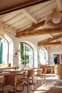 Un comedor con techos de madera y mesas y sillas. en Capelongue, a Beaumier hotel & Spa, en Bonnieux