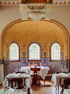 a dining room with tables and chairs and windows at Grand Hotel Belvedere, a Beaumier Hotel in Wengen +118 photos