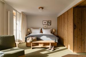 a bedroom with a bed and a green chair at Grand Hotel Belvedere, a Beaumier Hotel in Wengen +75 photos