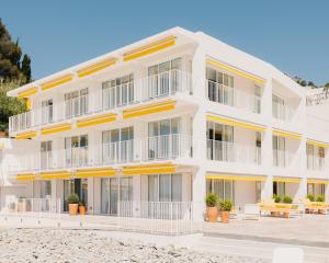 a white building with orange accents on the beach at Les Roches Rouges, a Beaumier hotel in Saint-Raphaël