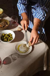 een persoon die met een mes op een bord eet bij Le Galinier Lourmarin, a Beaumier Guesthouse in Lourmarin