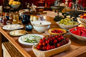 a table topped with bowls of fruits and vegetables at Le Galinier Lourmarin, a Beaumier Guesthouse in Lourmarin