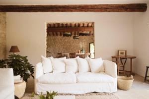 a white couch in a living room with a table at Le Galinier Lourmarin, a Beaumier Guesthouse in Lourmarin